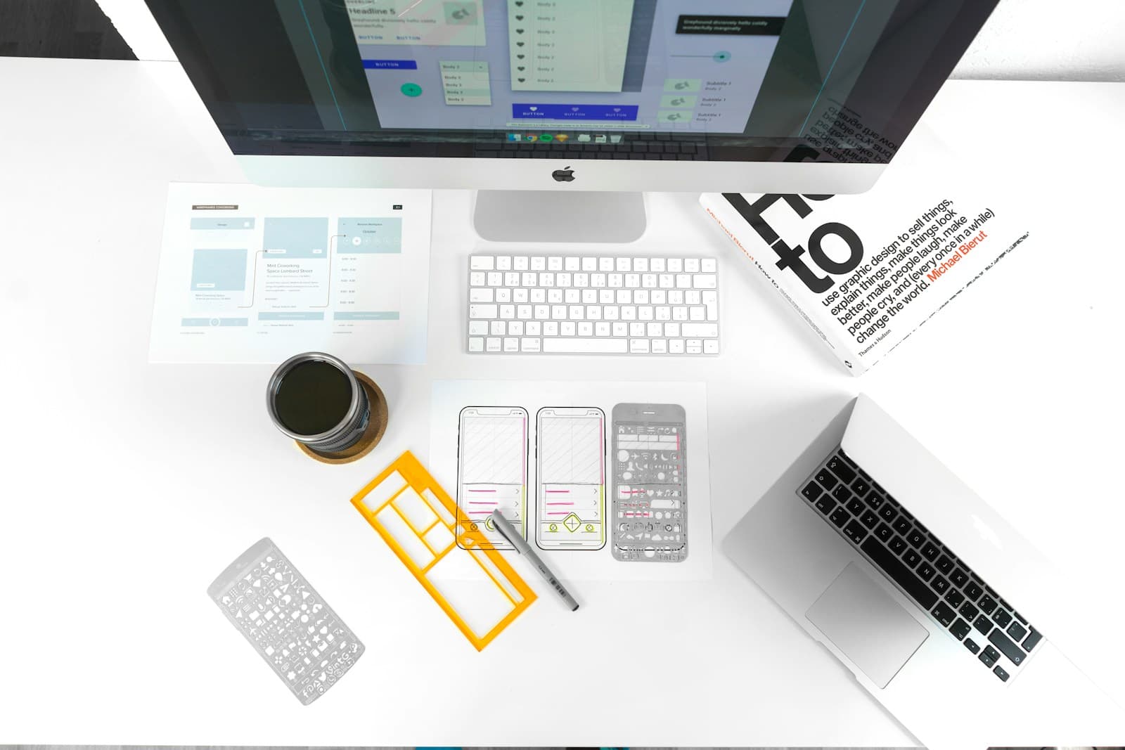 Silver MacBook Air on table near iMac